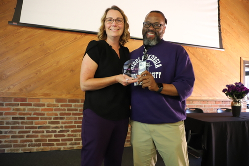 Staff hold their award at the Greatness Awards ceremony. 